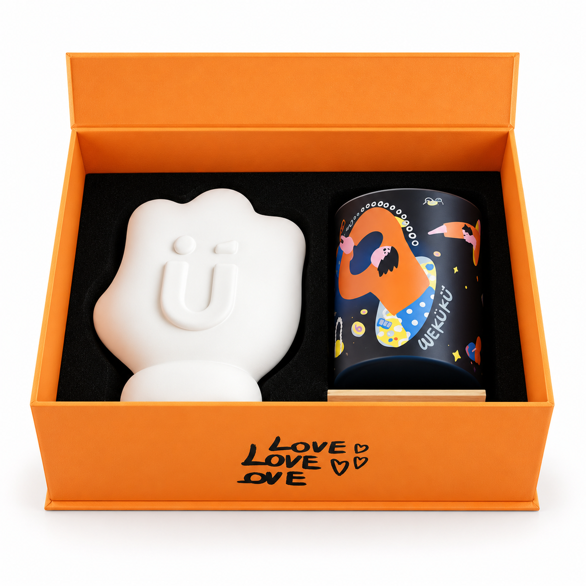 Confezione regalo Fortune aperta, con candela profumata da 200 g nel contenitore nero illustrato e supporto decorativo bianco a forma di mano.