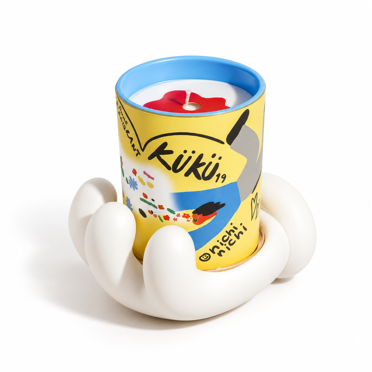 Candela profumata Speak Kindly da 200 g nel contenitore giallo illustrato, inserita nel supporto decorativo bianco a forma di mano, su sfondo bianco.