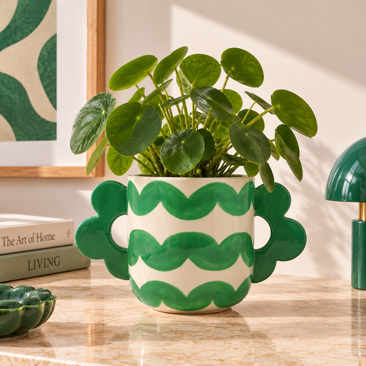 Cachepot Jacinta Wavy Rumba Qué Rico verde e crema con pianta Pilea, ambientato su un piano in pietra chiara in un interno contemporaneo.