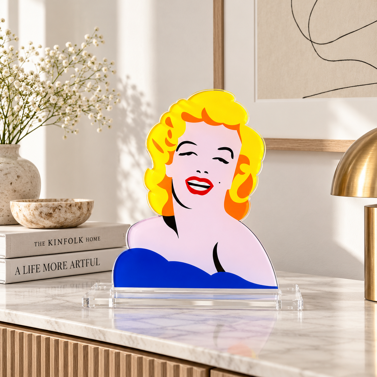 Scultura Hollywood's Dream di Marco Lodola raffigurante Marilyn Monroe, esposta su una consolle in marmo in un ambiente contemporaneo.