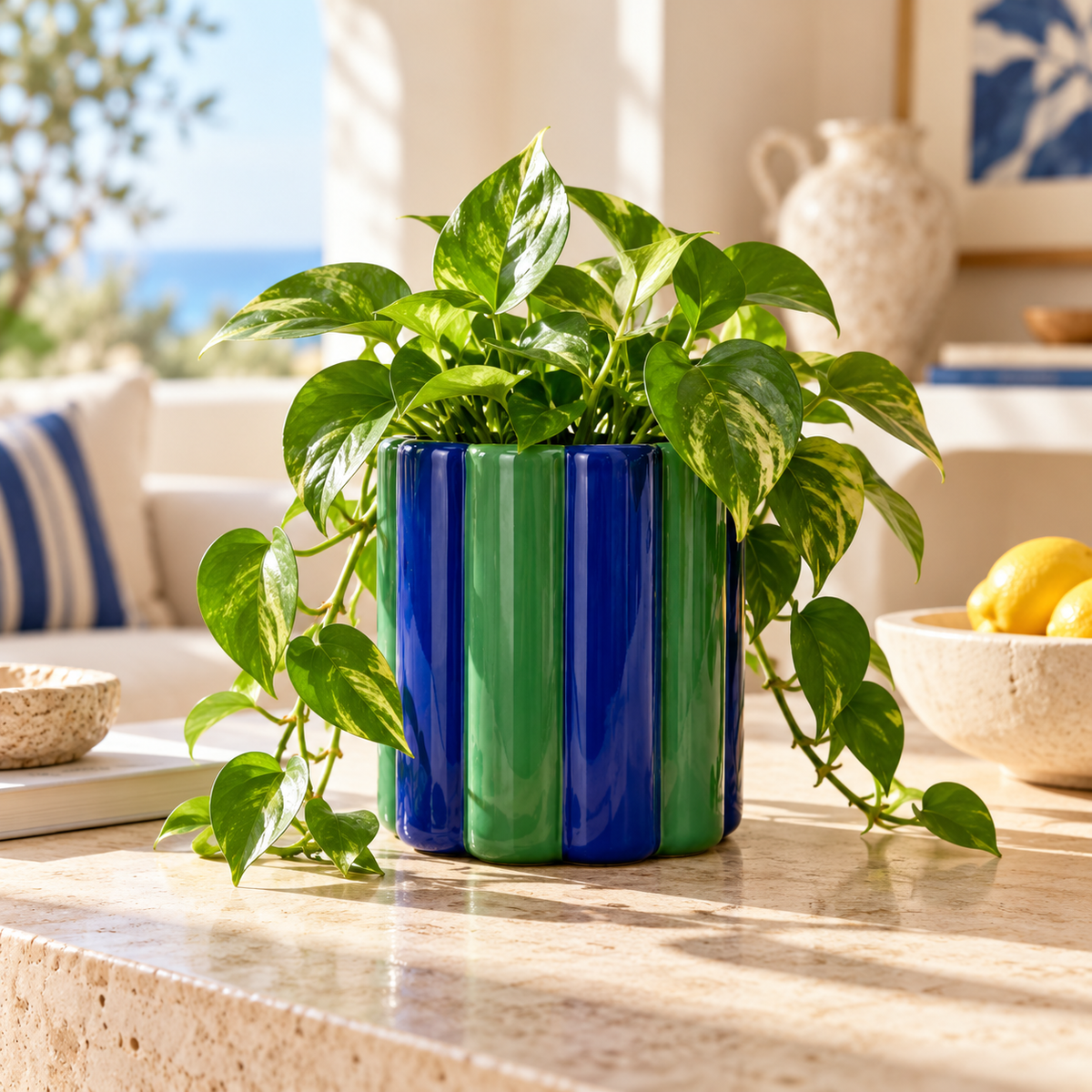 Vaso Small Qué Rico verde e blu in ceramica lucida, ambientato con una pianta verde su una consolle luminosa.