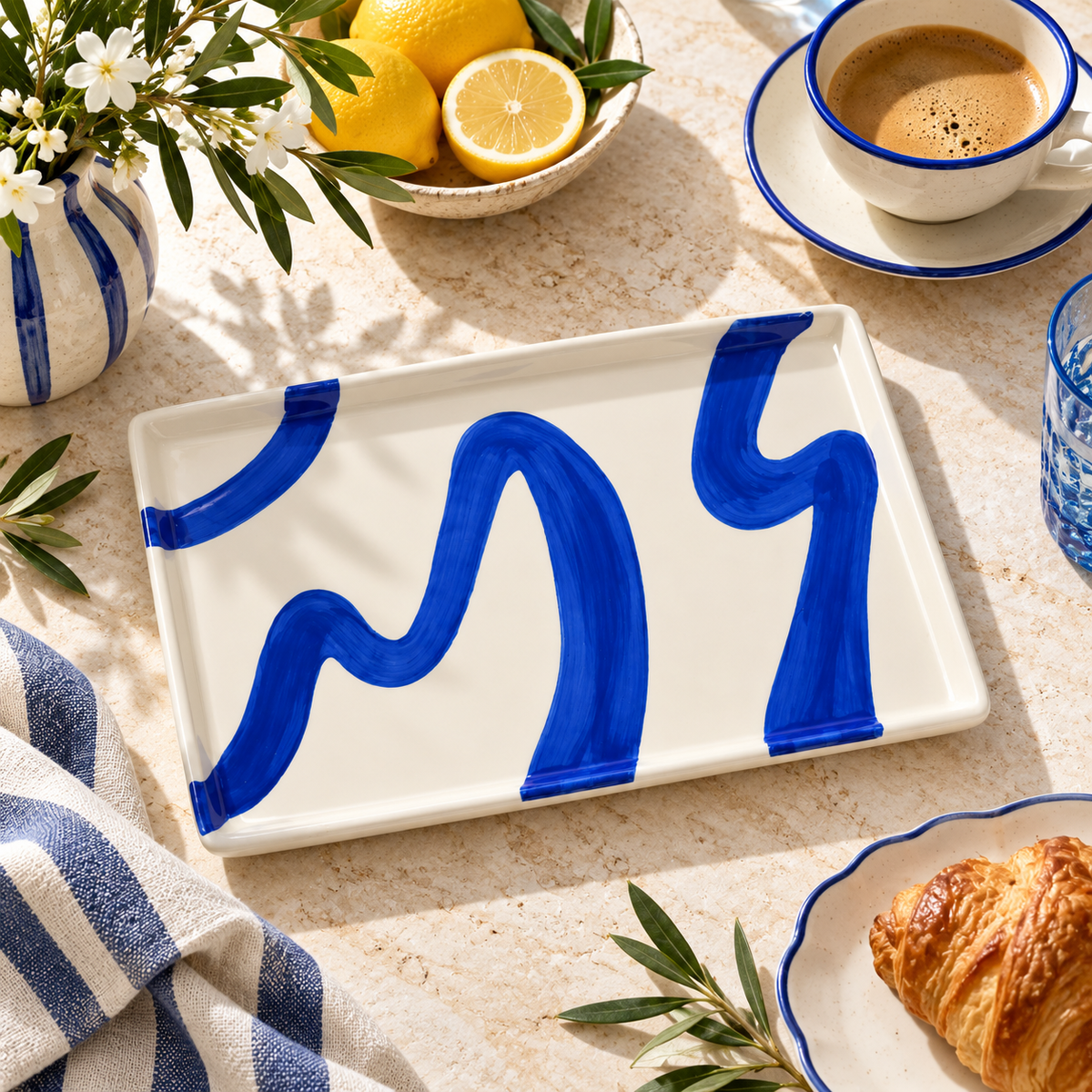 Vassoio Alejandro Qué Rico in ceramica bianca con pennellate sinuose blu cobalto, forma rettangolare e bordi rialzati, su fondo bianco.