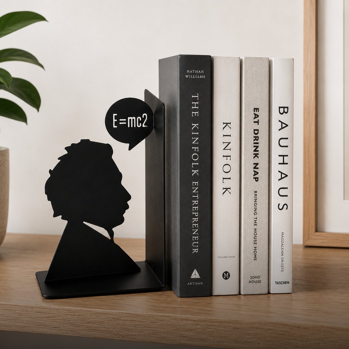 Fermalibri di design su una mensola con libri e piante