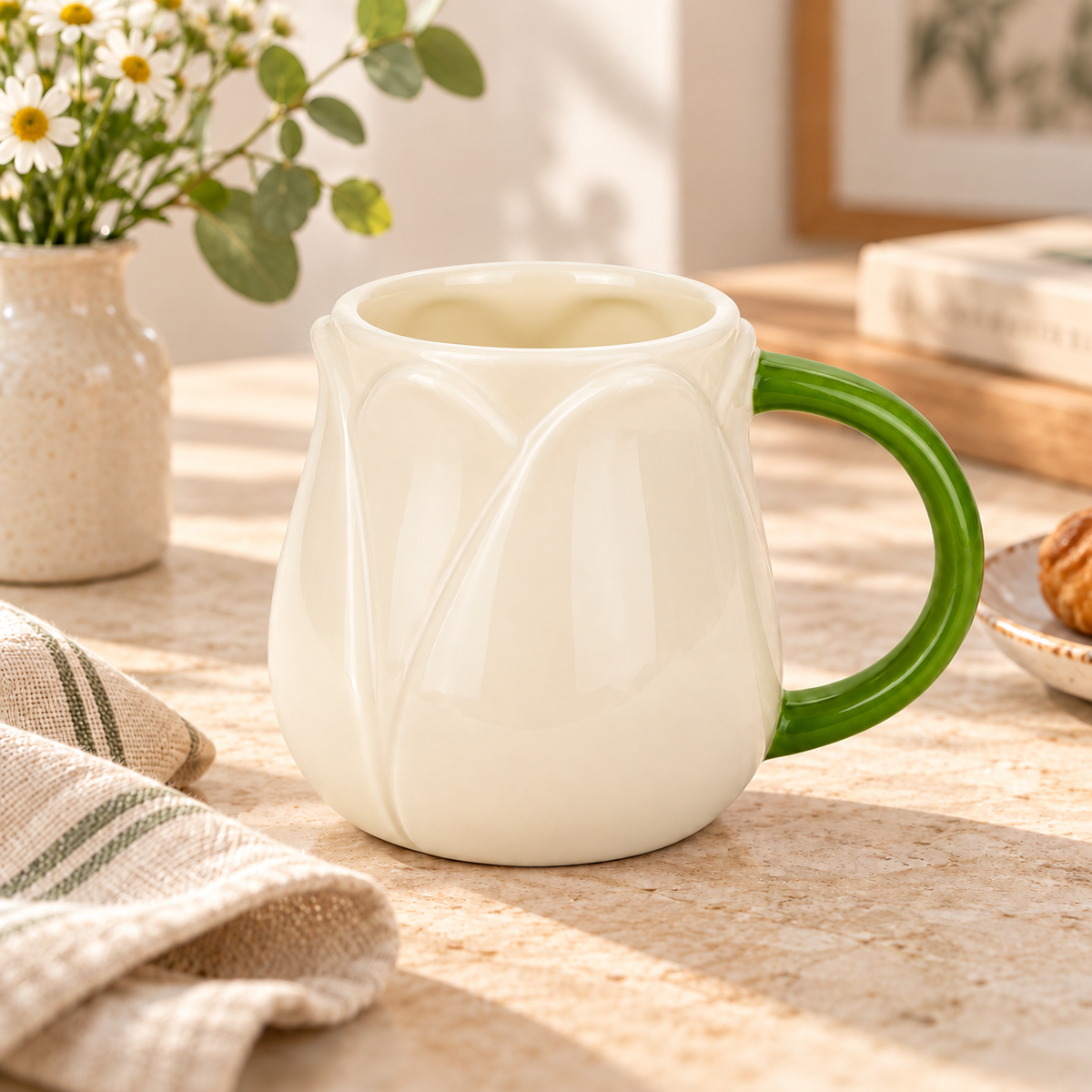 Mug Tulip Balvi bianca con manico verde, su una tavola luminosa con fiori e dettagli naturali.
