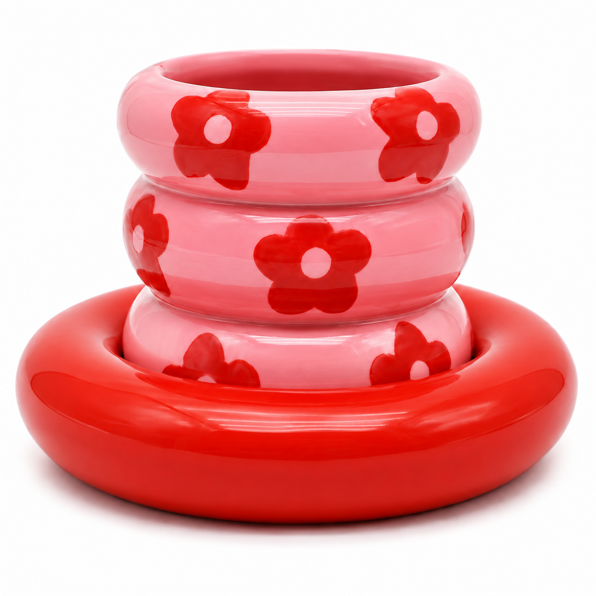 Tazza Casimiro Qué Rico in ceramica rosa con decorazioni a fiori rossi e piattino rosso coordinato, su sfondo bianco.