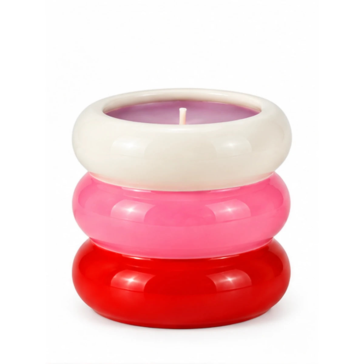Candela Qué Rico in contenitore di ceramica con tre anelli sovrapposti bianchi, rosa e rossi e cera color lilla, su sfondo bianco.