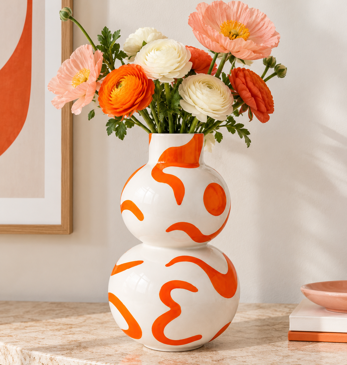 Vaso Isla Sol y Sombra Qué Rico bianco e arancione con fiori rosa, arancioni e bianchi, ambientato su una consolle in pietra chiara.