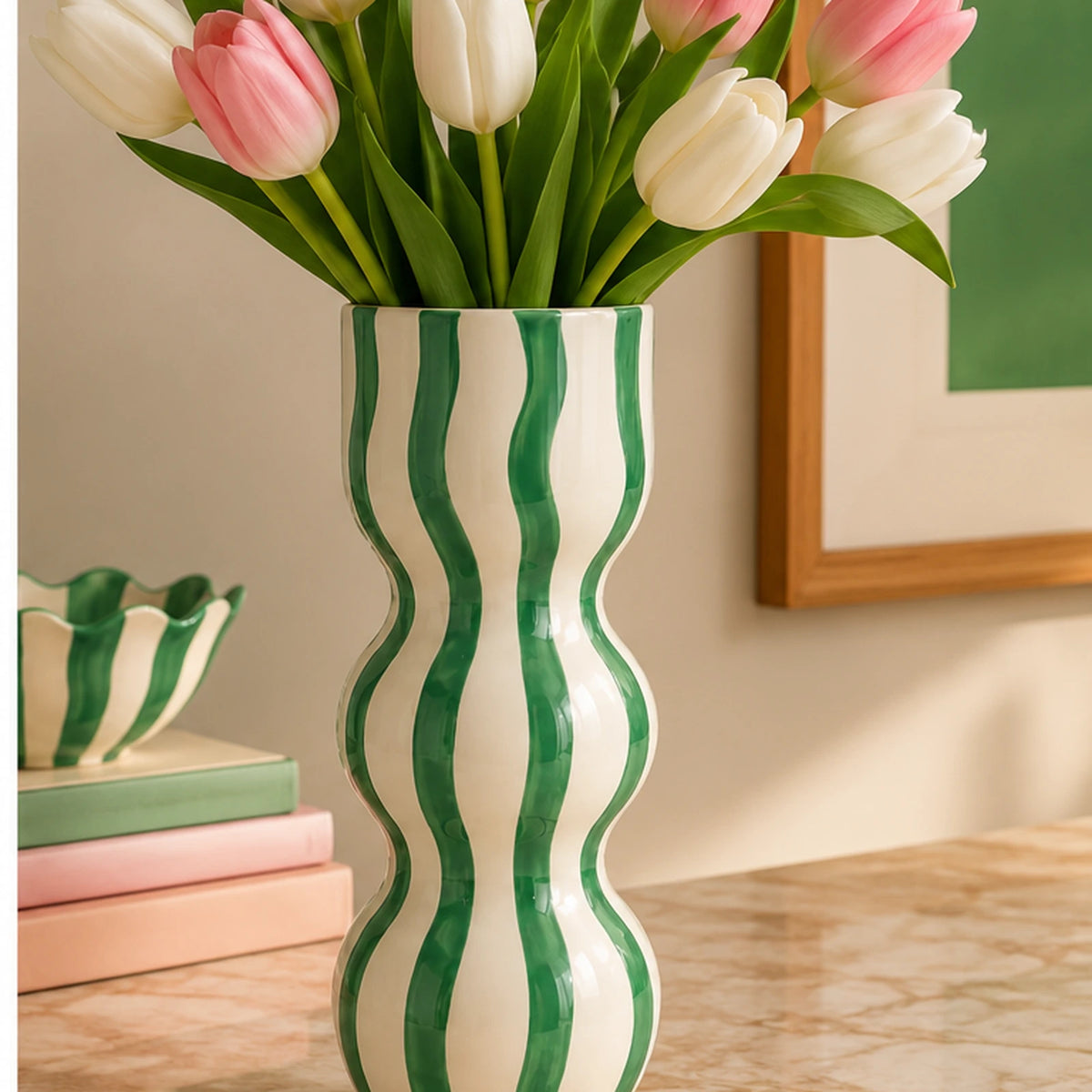 Vaso Raquel Qué Rico a righe verdi con tulipani rosa e bianchi, ambientato su un piano in marmo in un soggiorno contemporaneo.
